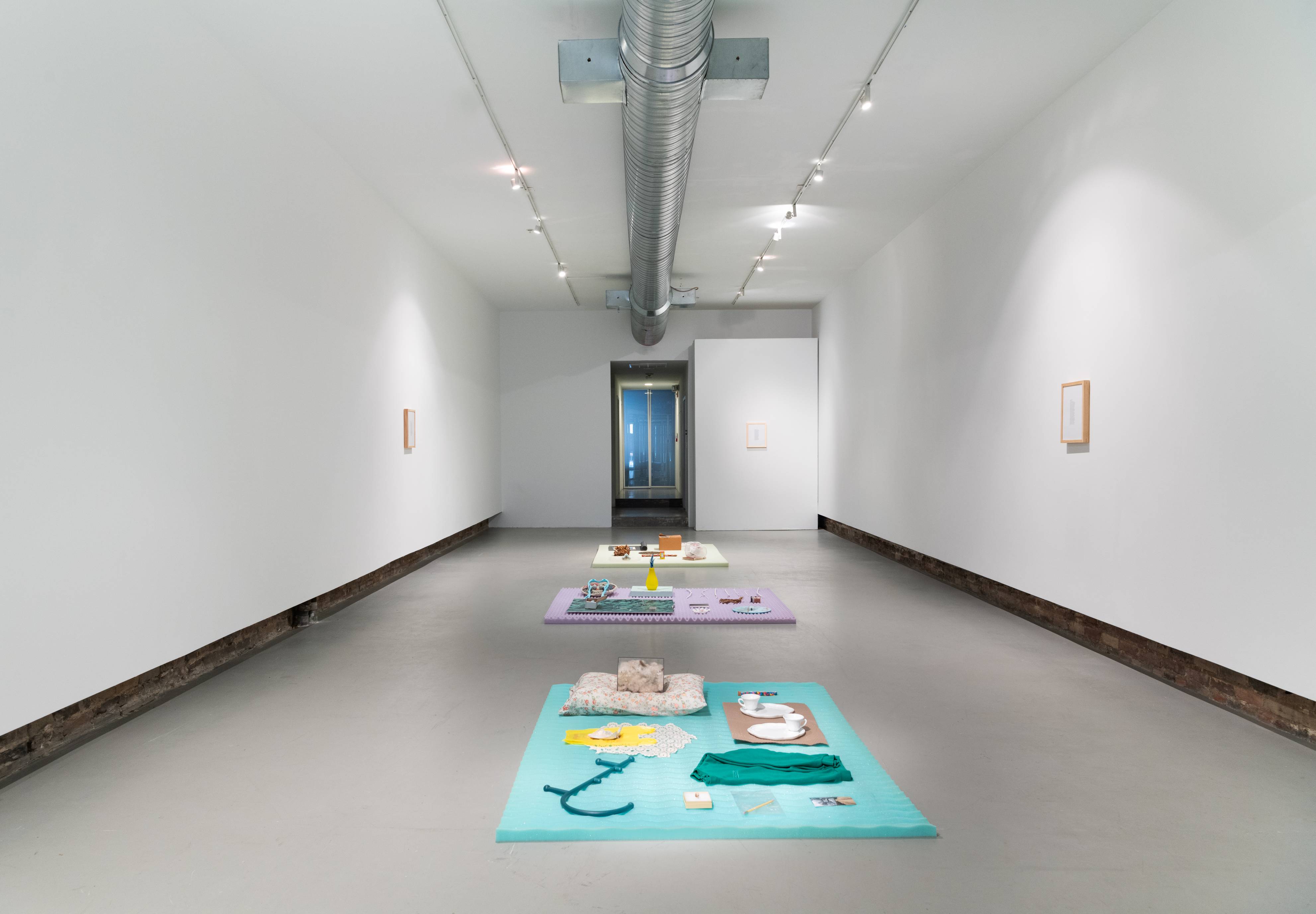 Gallery with three brightly colored flat sculptures on the floor 