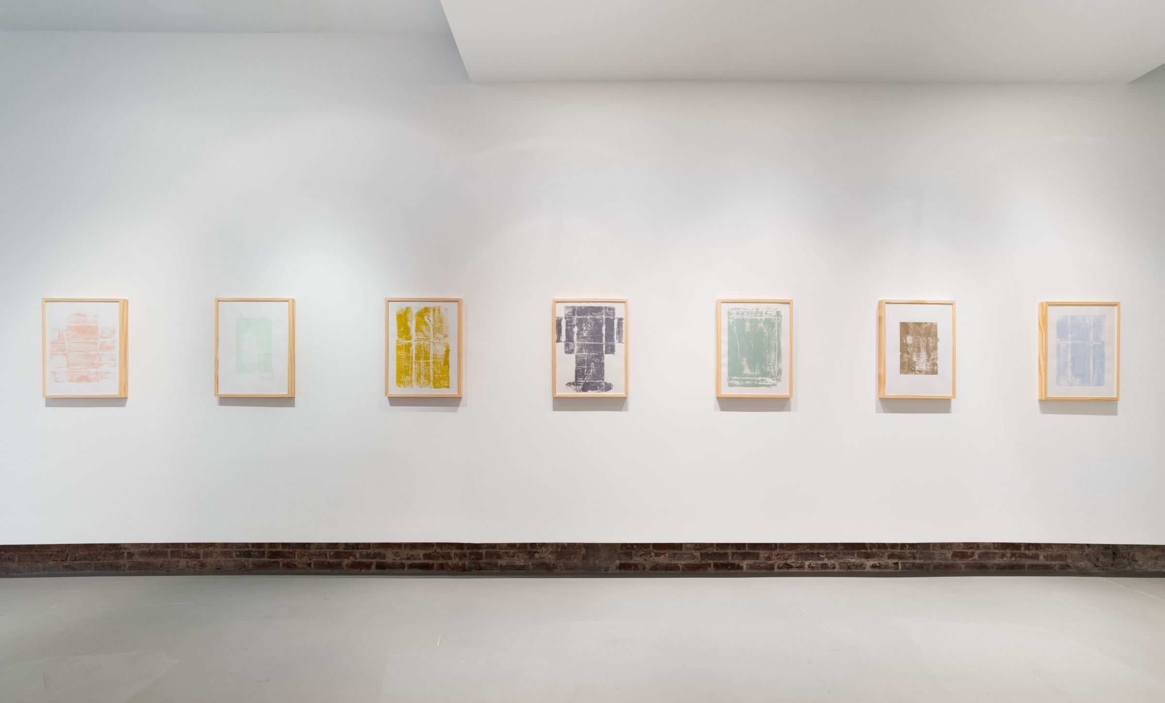 Row of framed prints hanging on a white wall 